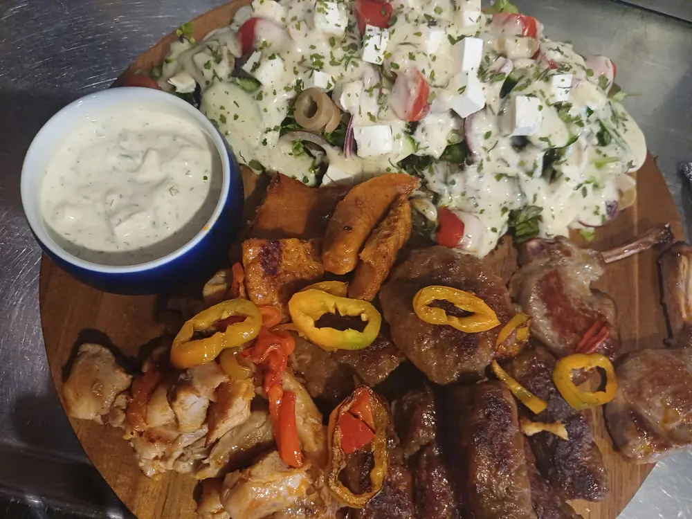 Grillades mixtes sur planche : poulet, qofte, qebap, côtelettes d'agneau, poivrons, salade et sauce au yaourt