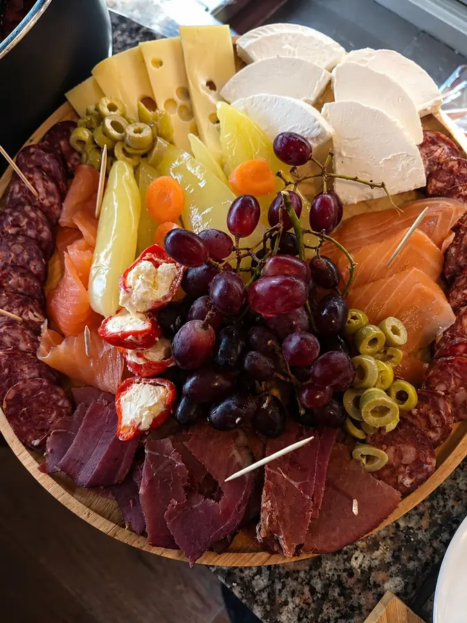 Plateau apéritif Konaku : charcuterie séchée, fromages, saumon fumé, raisins, olives et poivrons farcis